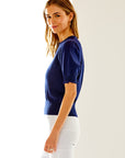 Woman in navy short sleeve scallop sweater