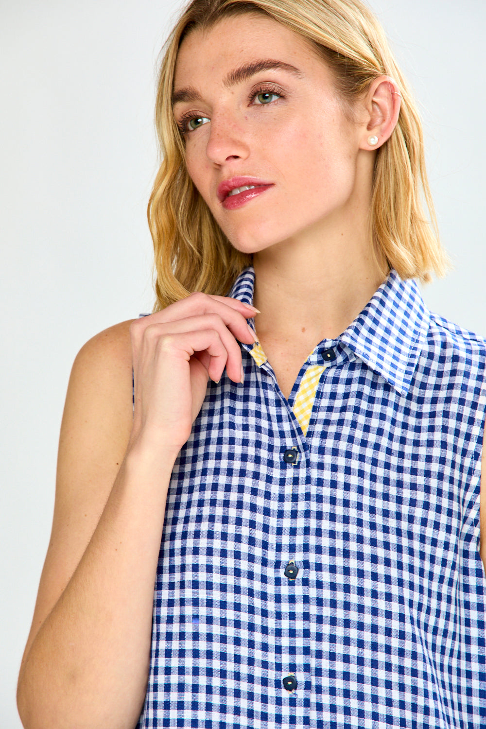 Woman wearing a blue and white checkered dress against a plain background