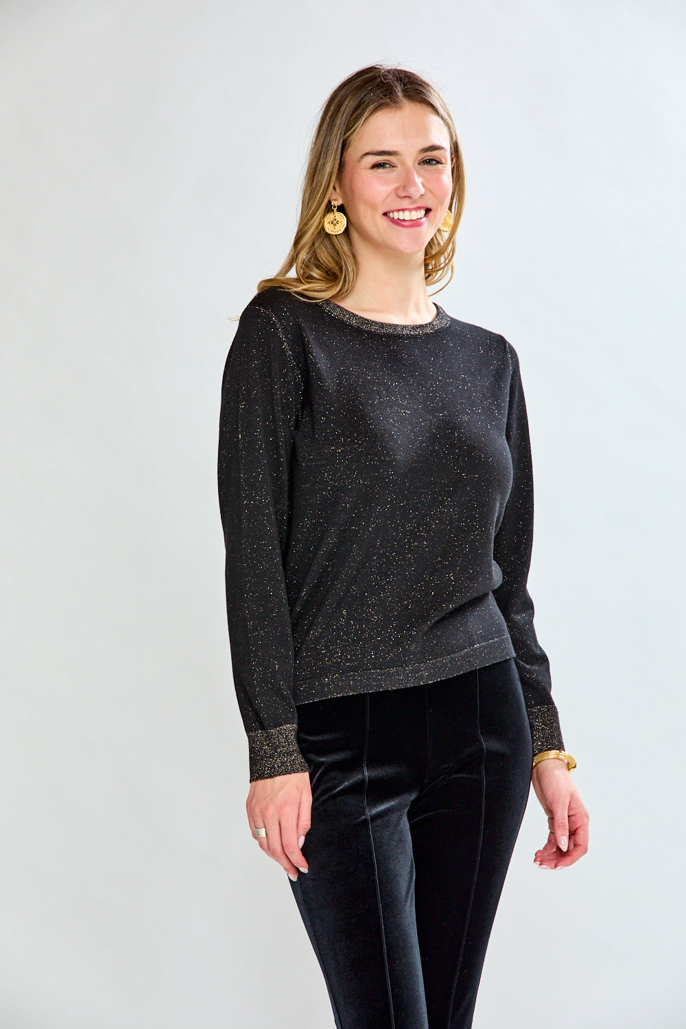 Woman wearing a black sweater and black pants on a white background