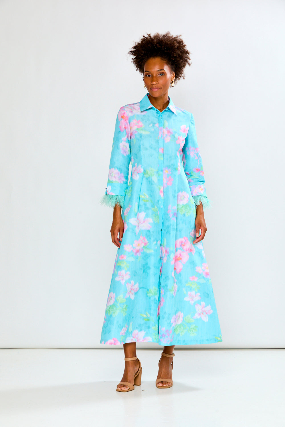 Woman wearing a light blue floral dress on a white background