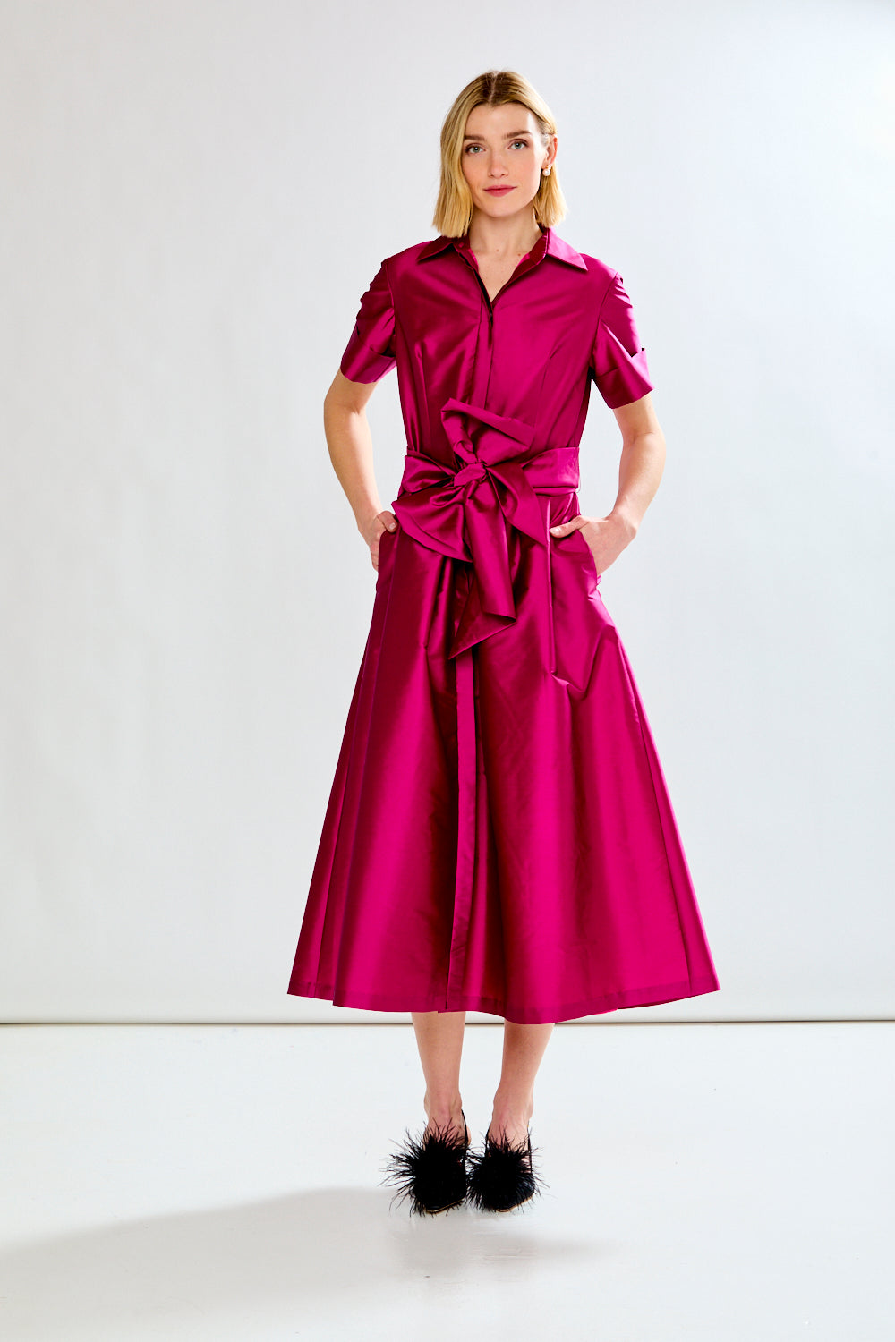 Woman wearing a pink dress with a white background