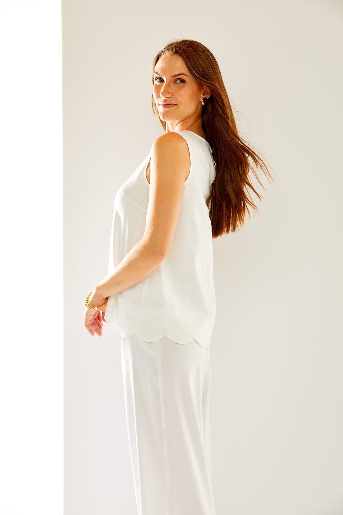 Woman in white top with scallop detail