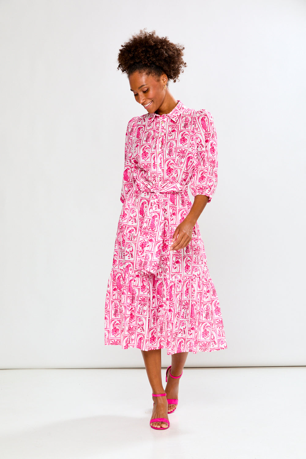 Woman wearing a pink and white patterned dress on a white background