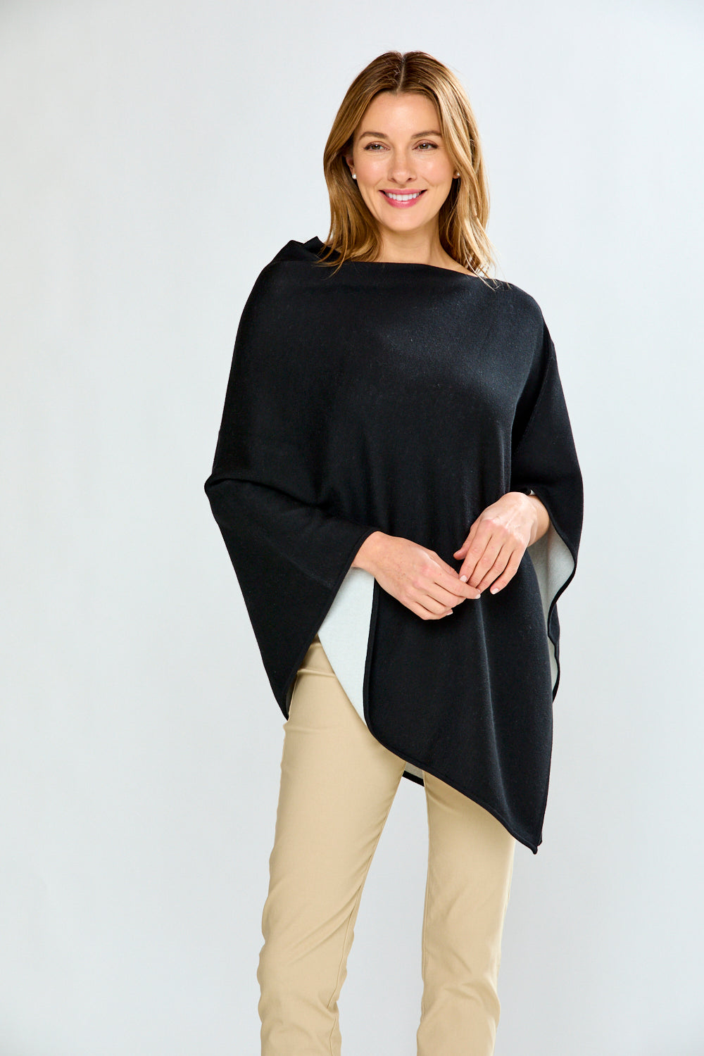 Woman wearing a black poncho over a white background