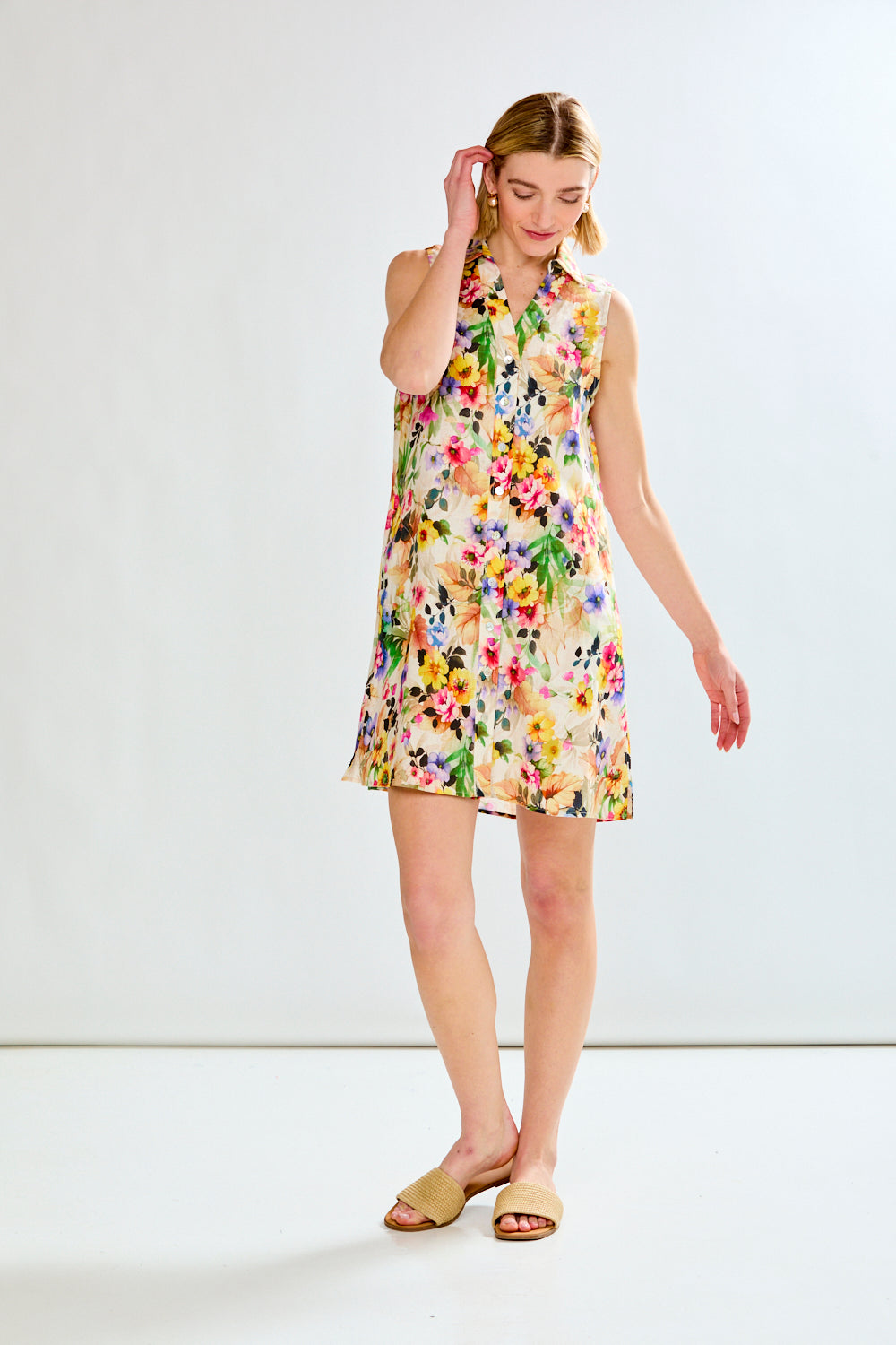 Woman wearing a colorful floral dress against a white background