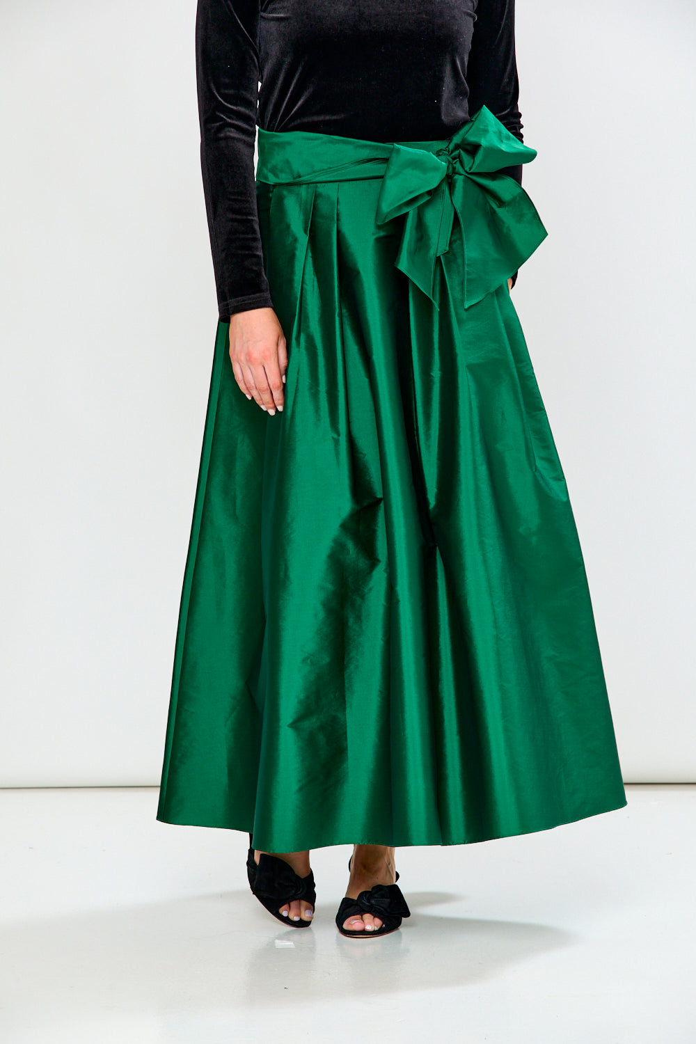 Woman wearing a Black top and Emerald skirt on a white background