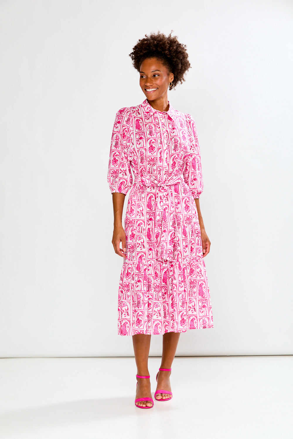 Woman wearing a pink and white patterned dress on a white background