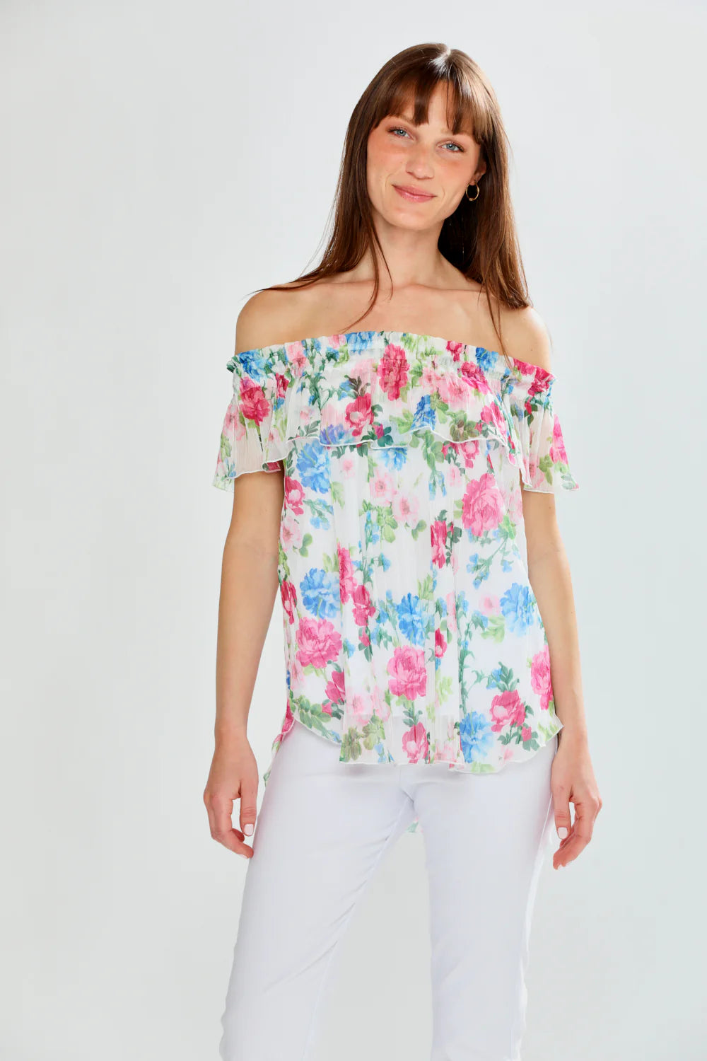 Woman wearing a floral off-shoulder top against a plain background