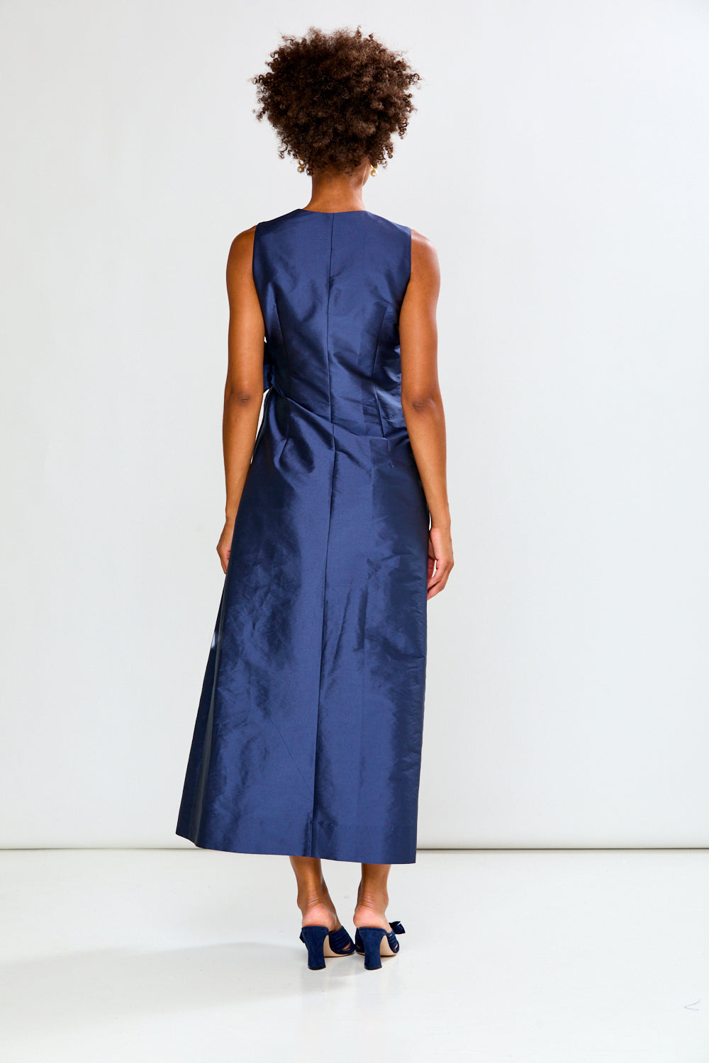 Woman wearing a blue dress against a white background