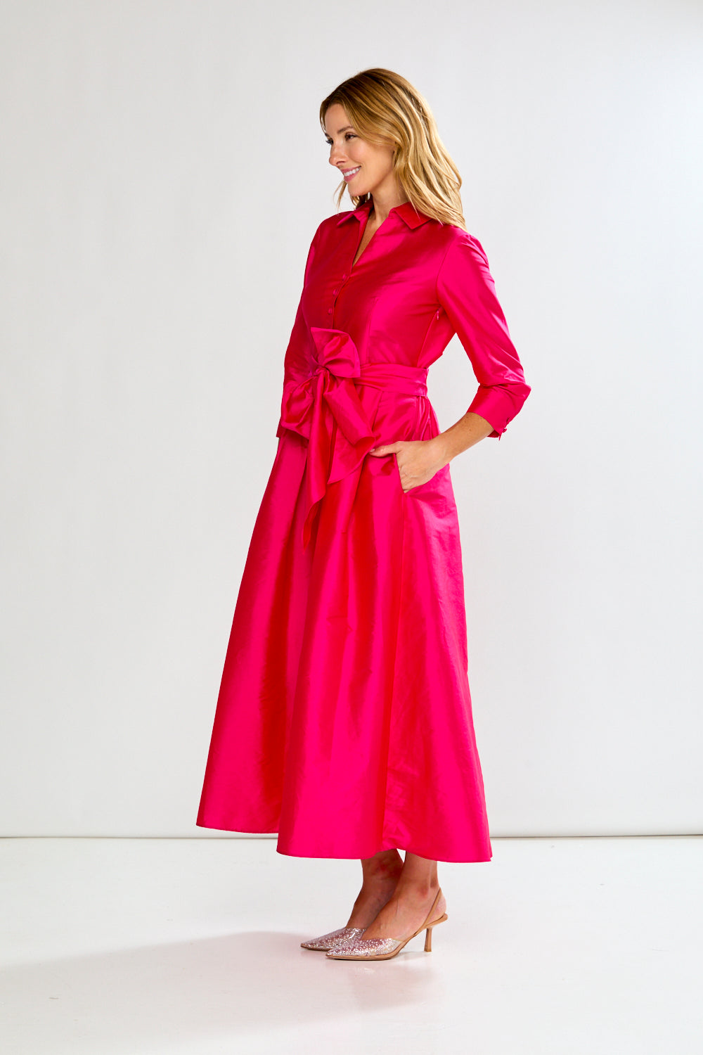 Woman wearing a bright pink dress against a white background