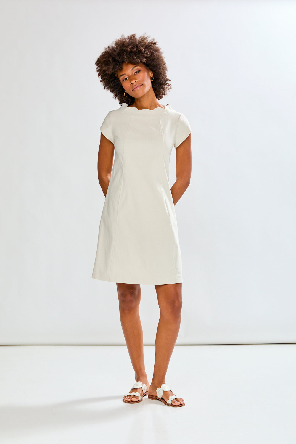 Woman wearing a stone dress against a plain background