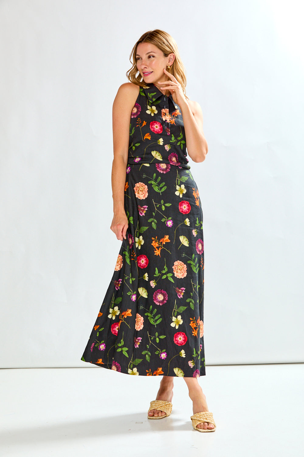 Woman wearing a black linen dress with multi colored flowers on it