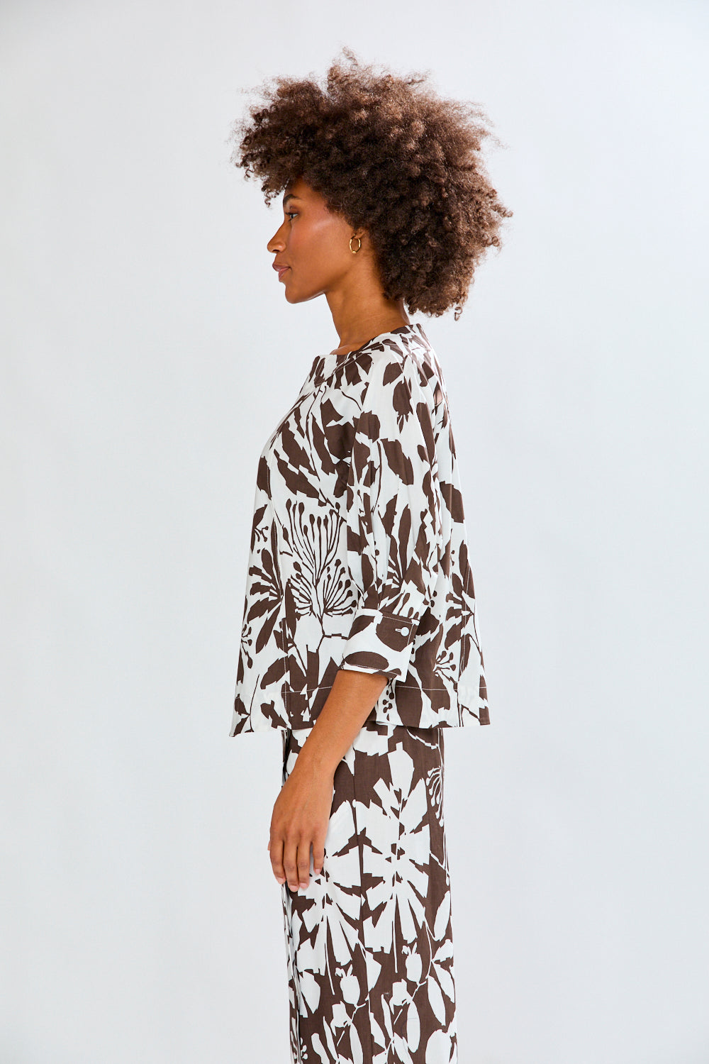 Woman wearing a patterned top on a white background