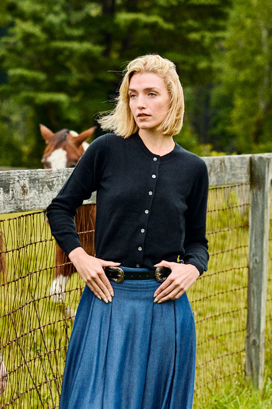 girl standing in a field in a sweater