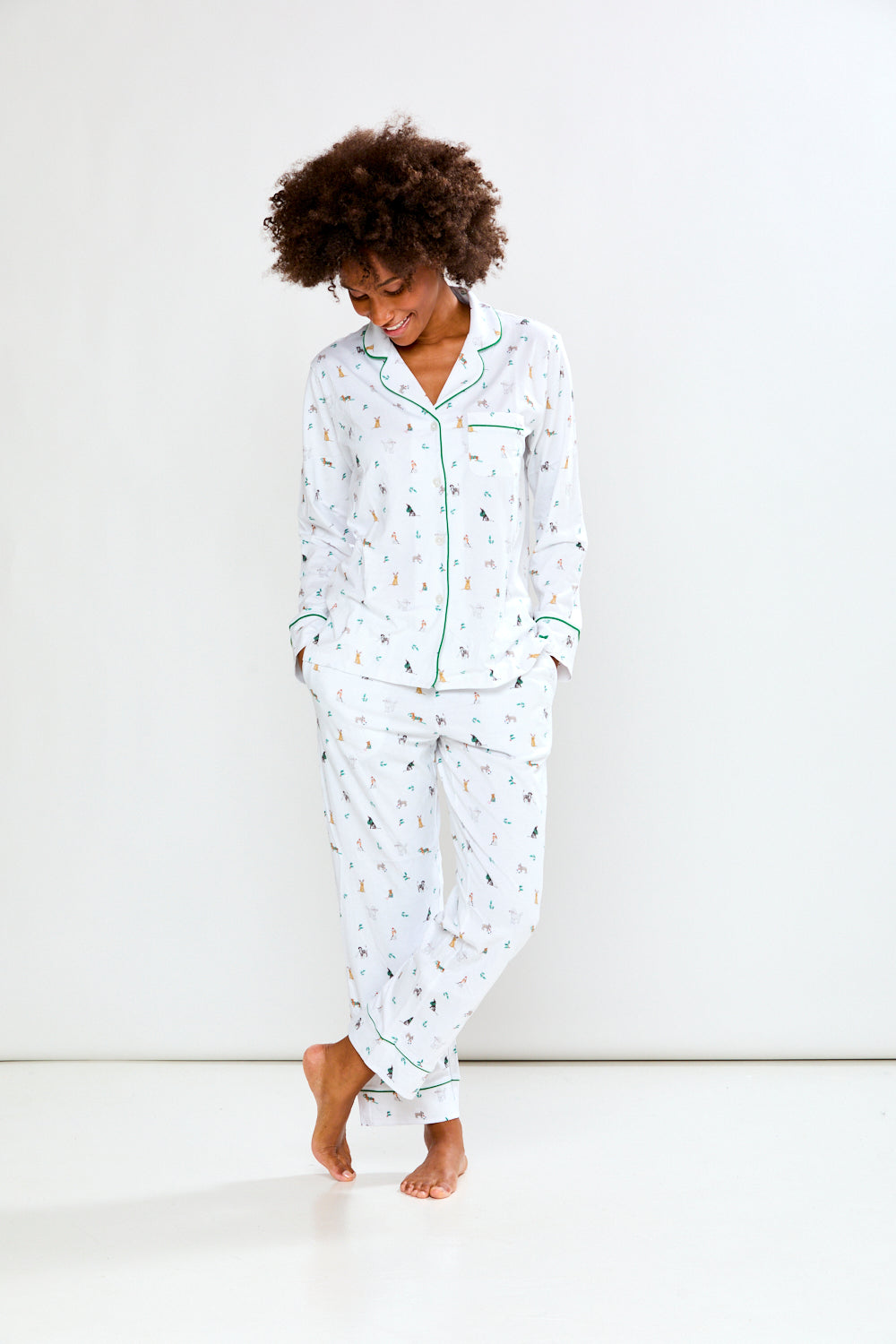 Woman wearing a white pajama set with a dog pattern on a white background