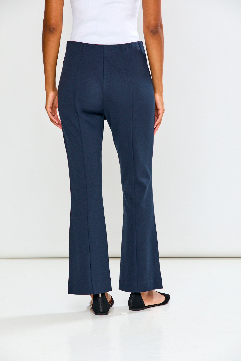 Navy blue flared pants worn by a person on a white background