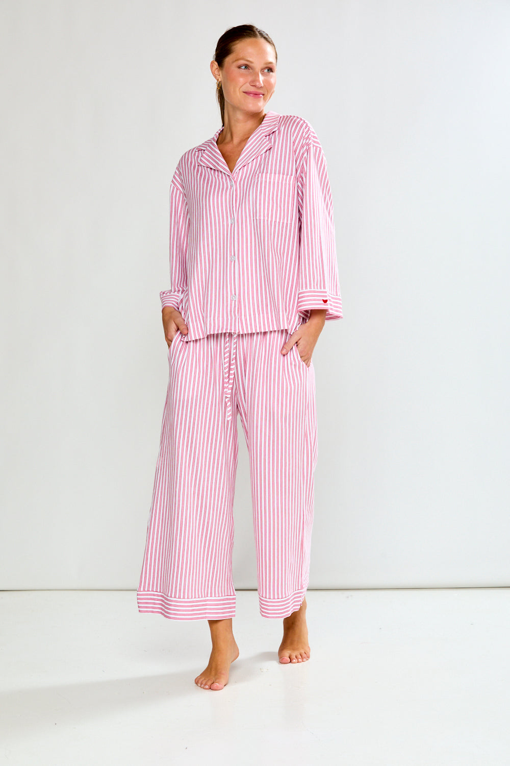 Woman wearing a red and white striped pajama set on a white background