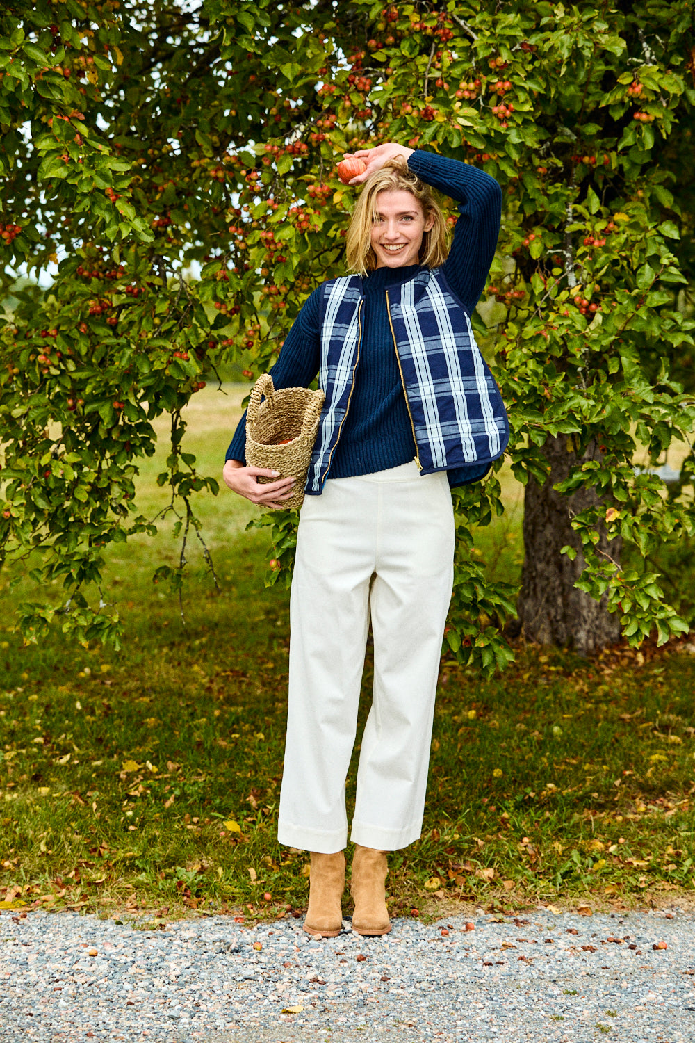 Woman standing outdoors with a tree in the background