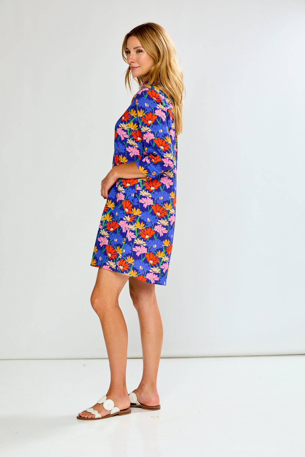 Woman wearing a colorful floral dress on a white background