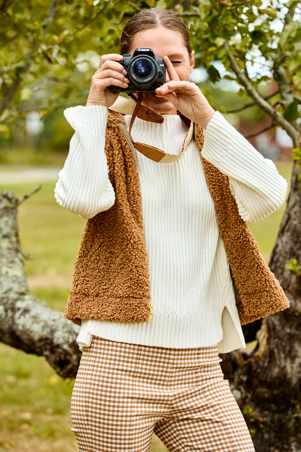 Person taking a photo with a camera in a natural setting