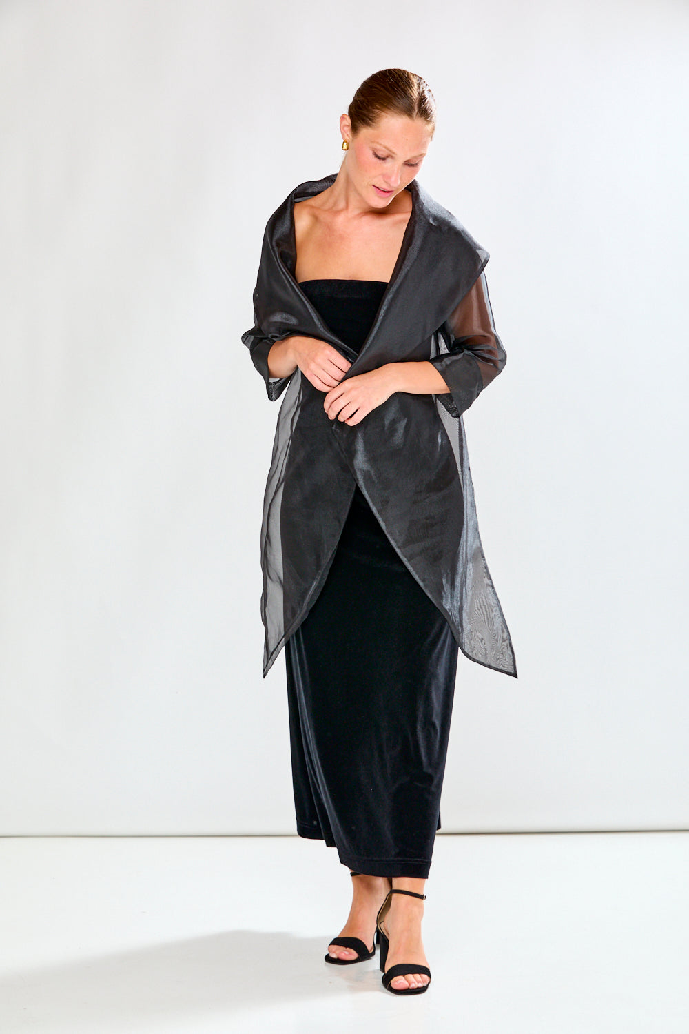 Woman wearing a black strapless dress against a white background