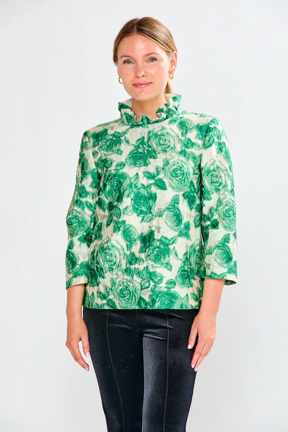 Woman wearing a green floral blouse against a white background