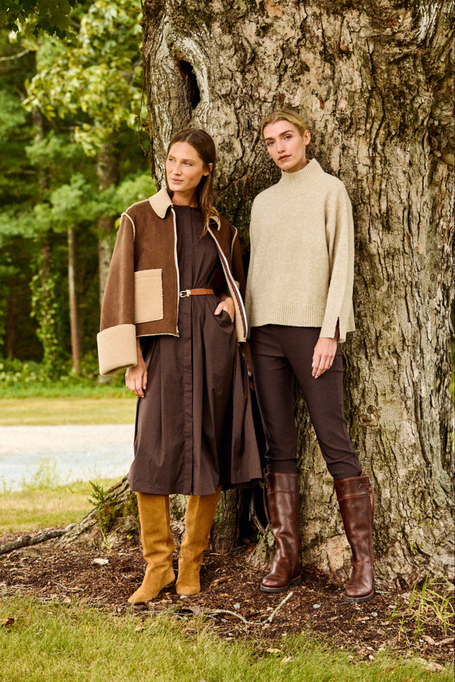 Two people standing next to a large tree in a natural setting