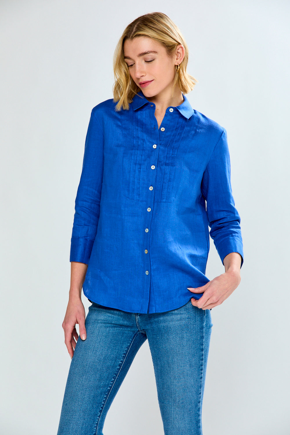 Woman wearing a blue shirt and jeans on a white background