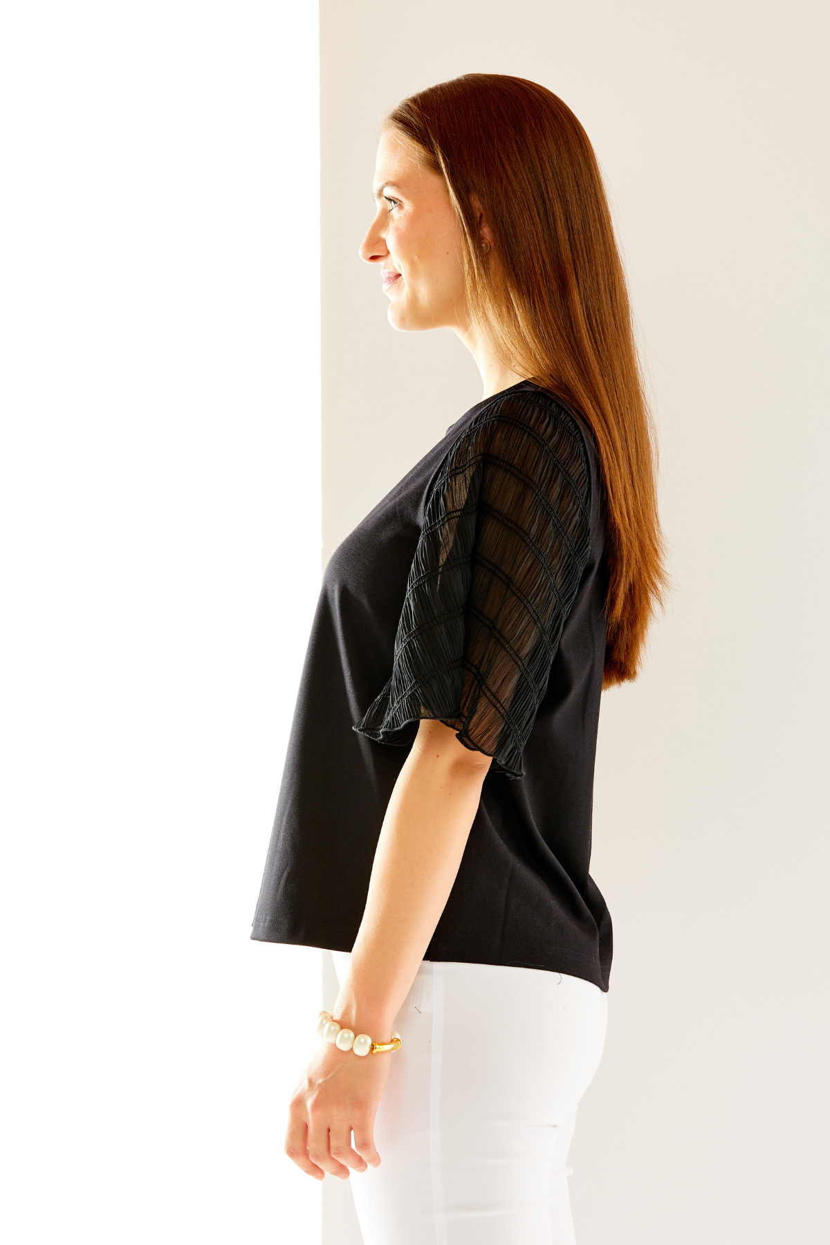 Woman in black top with butterfly sleeves