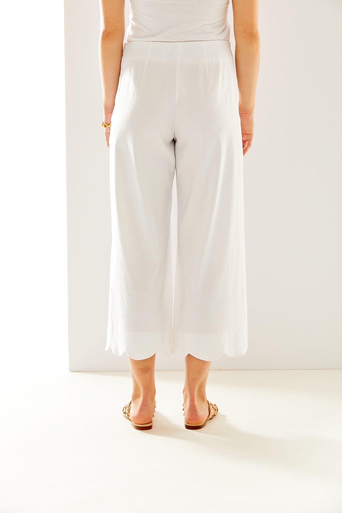 Woman in white pant with scallop hem