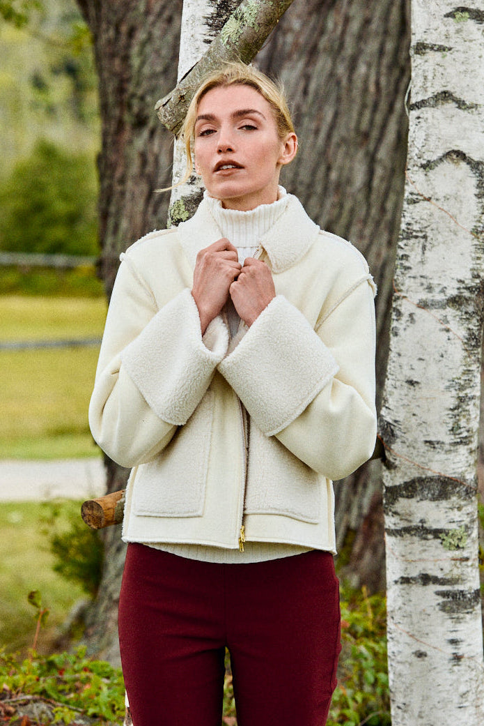 Woman wearing n ivory suede and sherpa jacket
