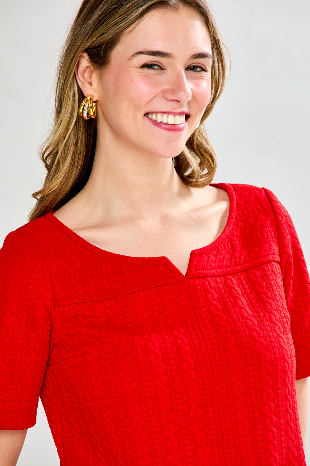 Woman wearing a red dress with a plain background