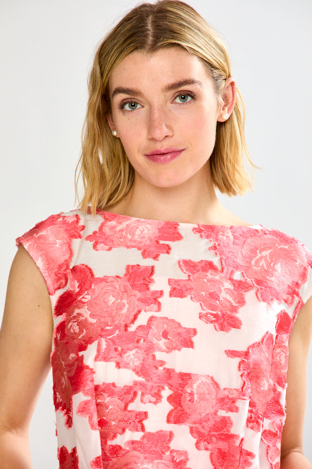 Woman wearing a pink and white floral dress on a white background