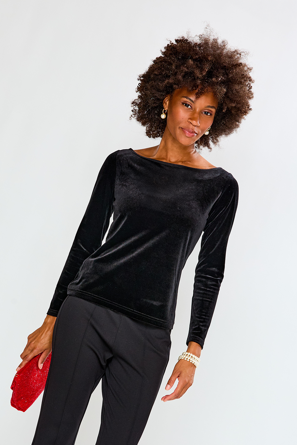 Woman wearing a black velvet top and pants against a white background