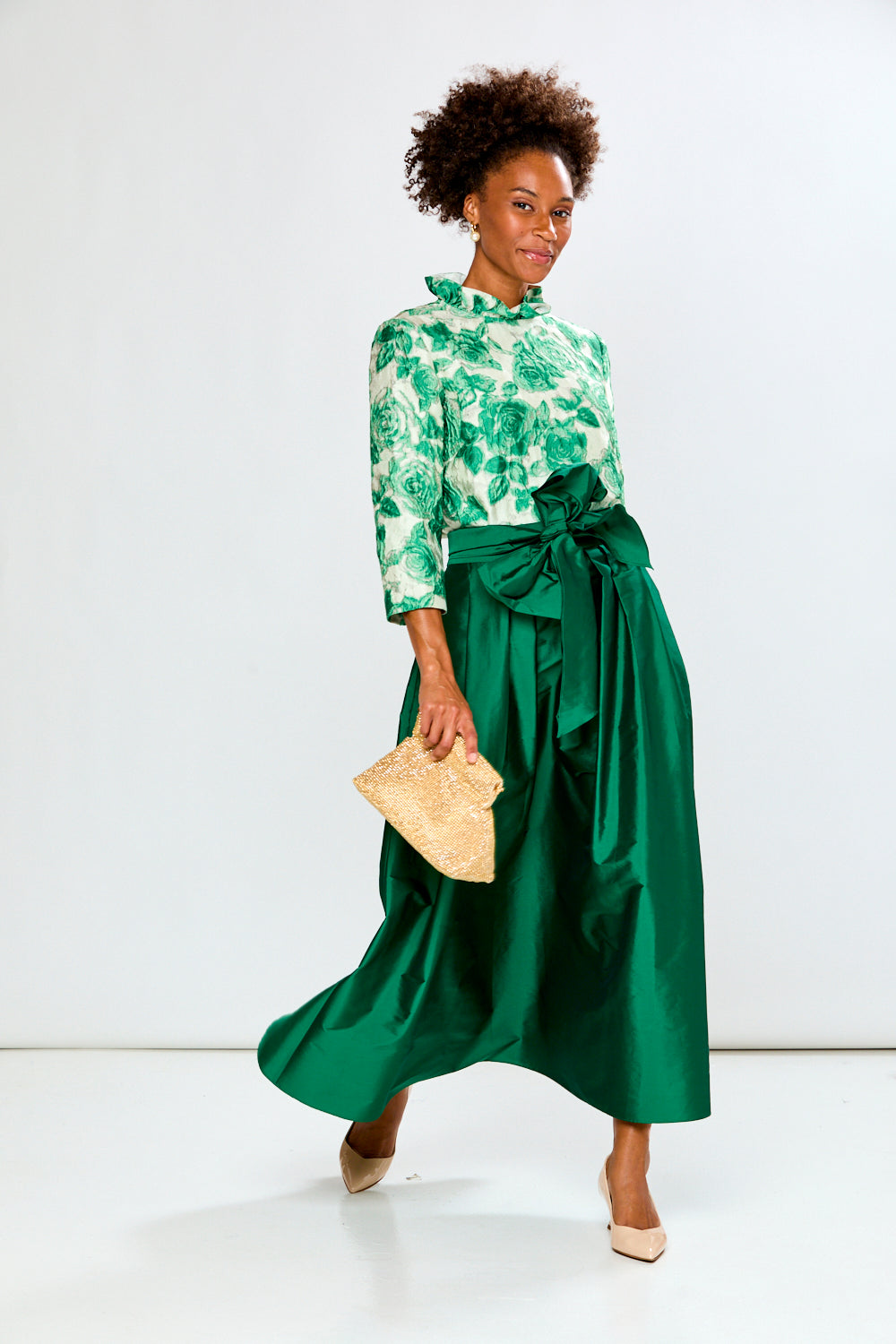 Woman wearing a green floral blouse against a white background