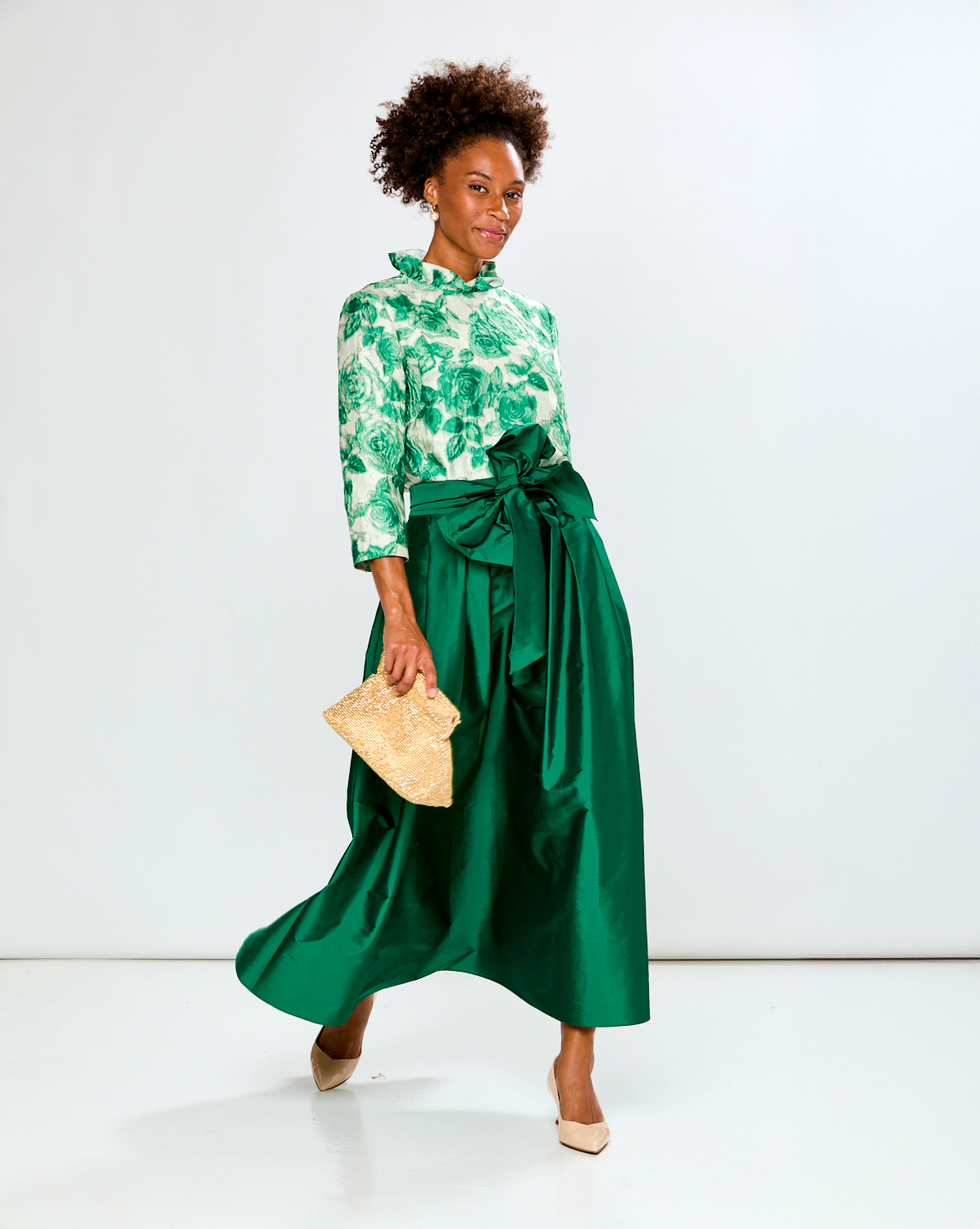 Woman wearing a green floral event blouse with a green taffeta skirt