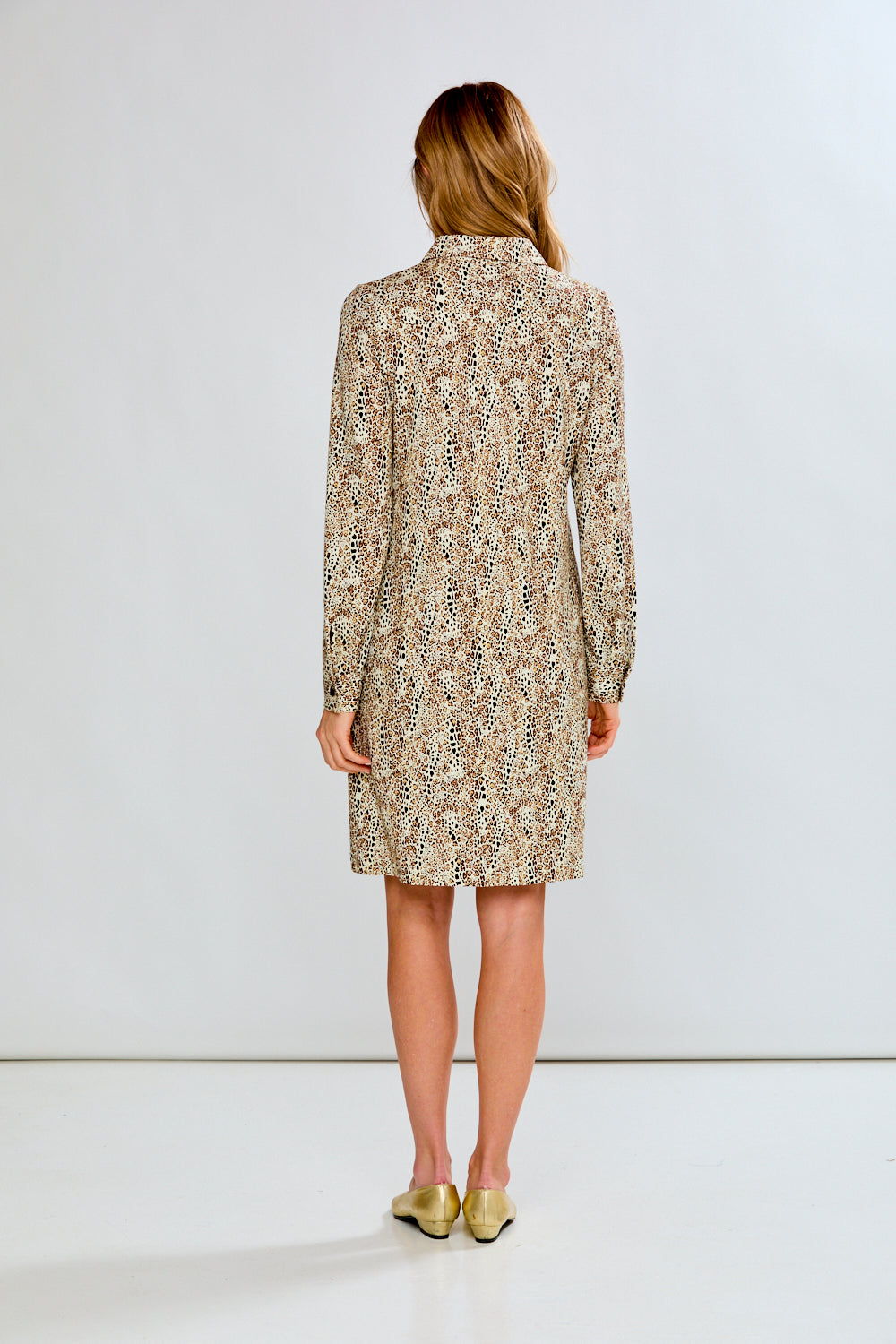 Woman wearing a patterned dress on a white background