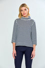 Woman wearing a black and white striped sweater with navy pants on a white background
