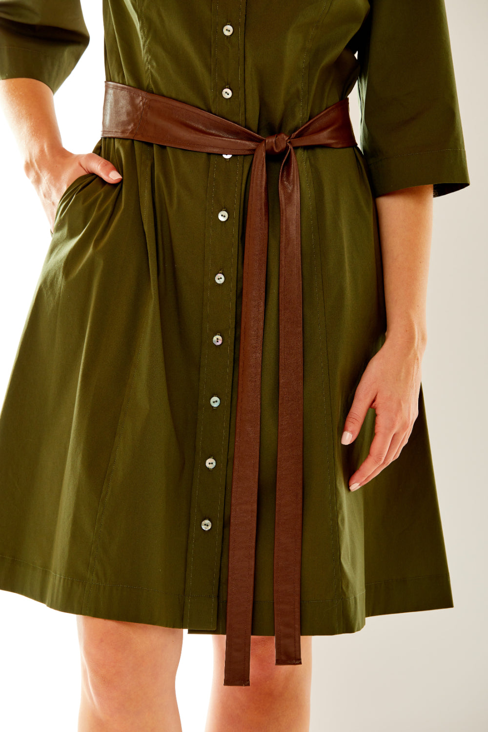 Woman in olive dress with faux leather sash