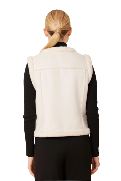 Woman wearing a white fur vest with gold buttons on a white background
