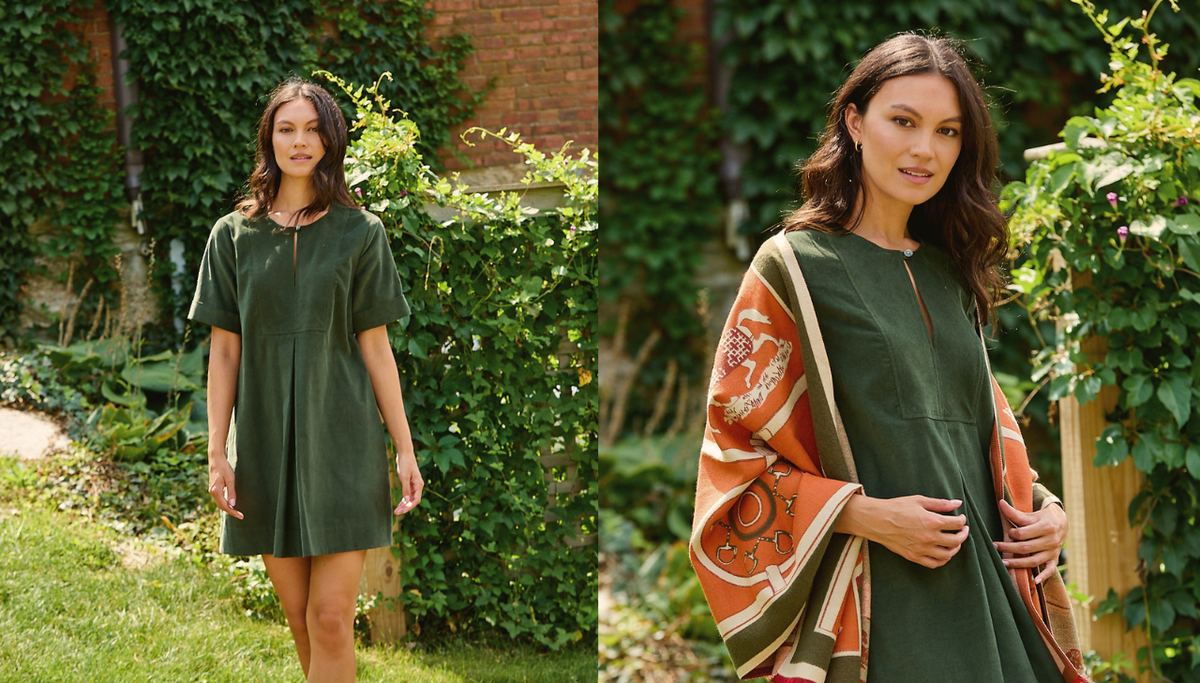 A woman modeling an olive green short-sleeve tunic dress in an outdoor garden setting, shown in a side-by-side split view. The left panel shows her wearing the dress alone, while the right panel shows her wearing the dress with a patterned orange and beige shawl draped over her shoulders.