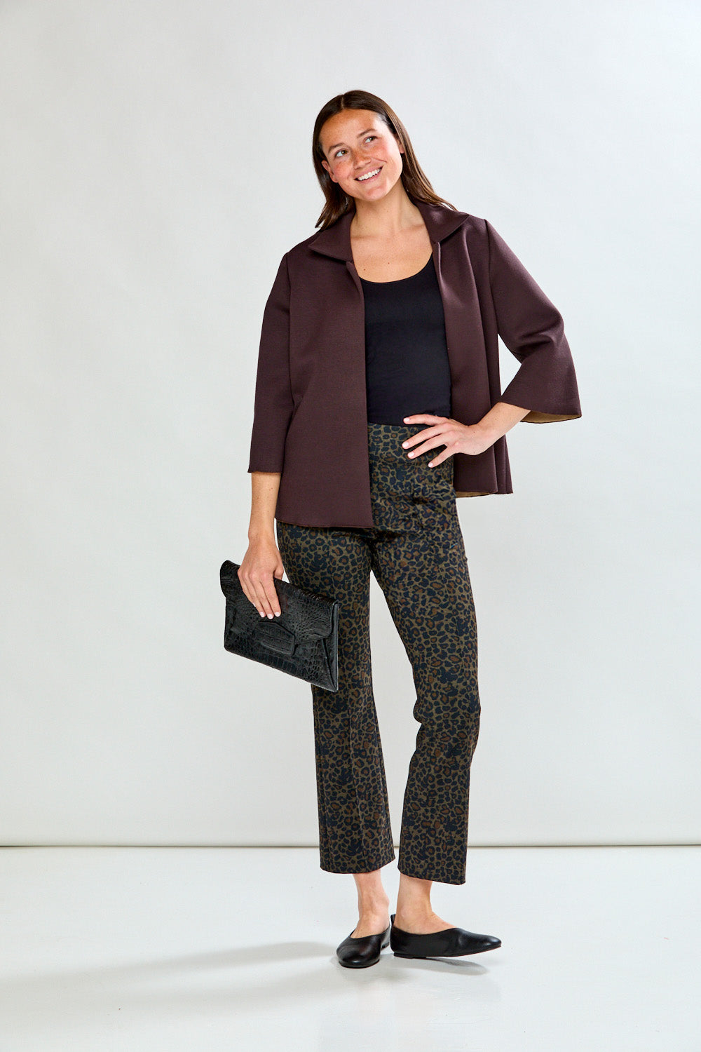 Woman wearing leopard print pants on a plain background
