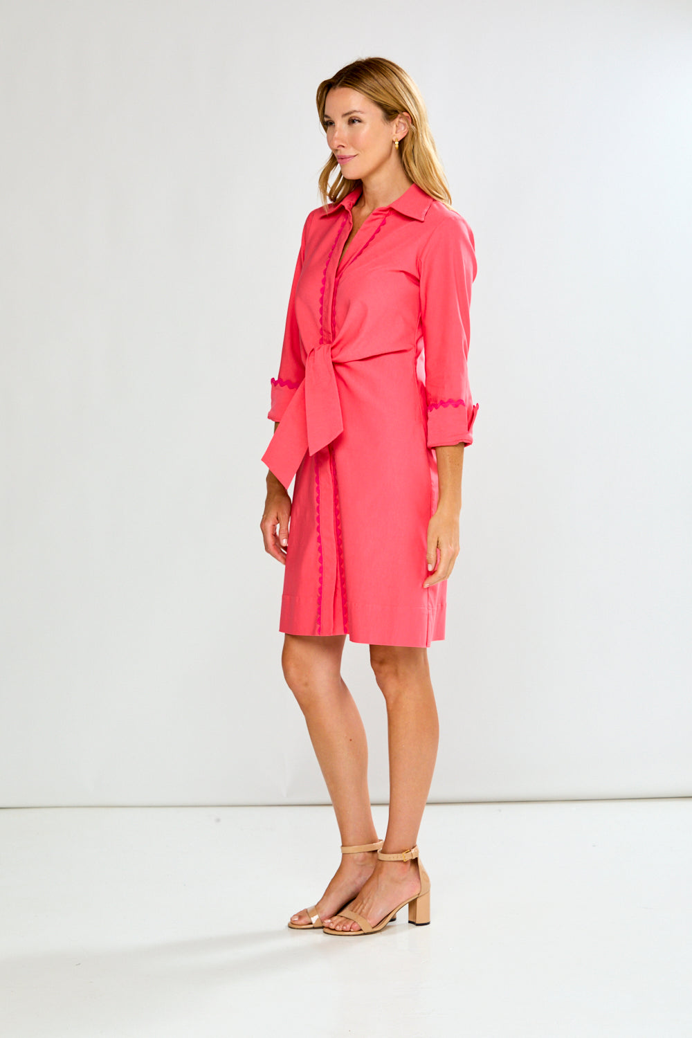 Woman wearing a pink dress with a white background