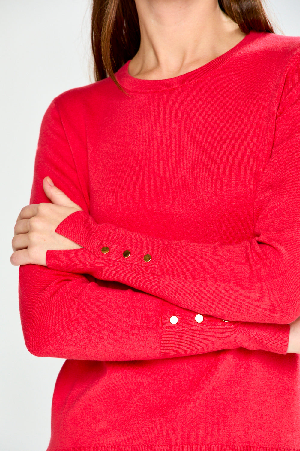 Woman wearing a pink sweater and light blue jeans on a white background