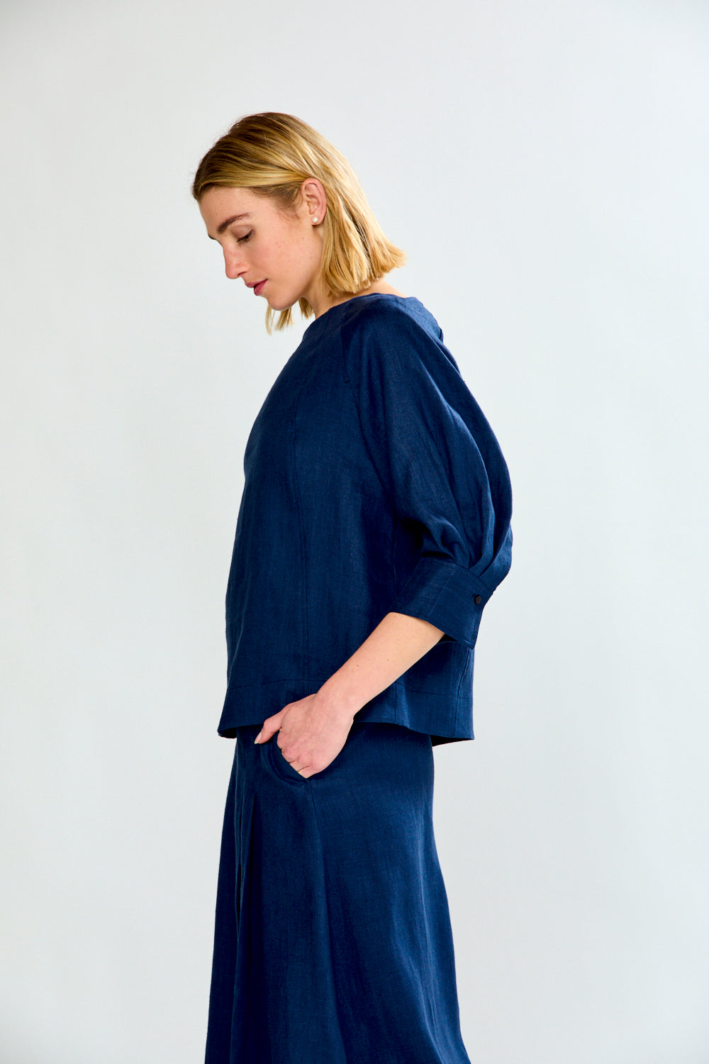 Woman wearing a navy blue outfit against a white background