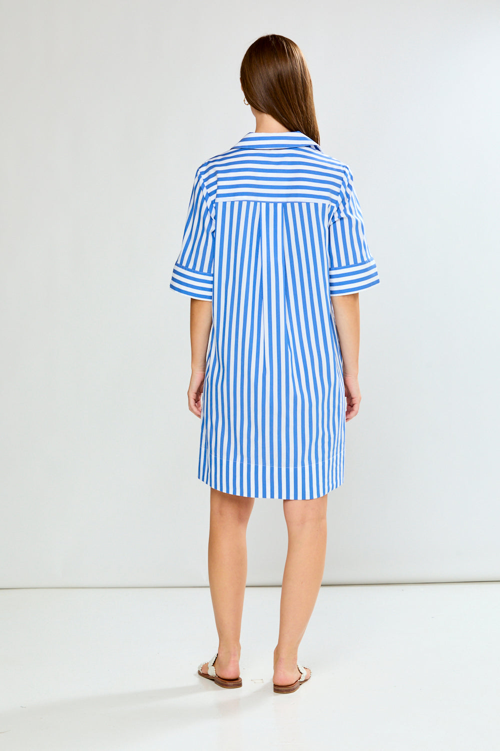 Woman wearing a blue and white striped dress on a white background