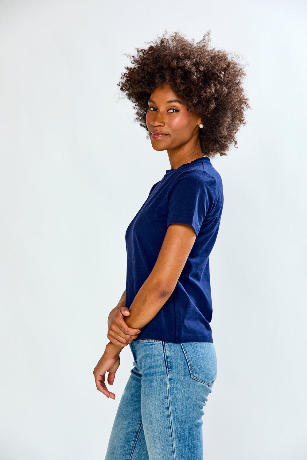 Woman wearing a blue shirt and jeans on a white background
