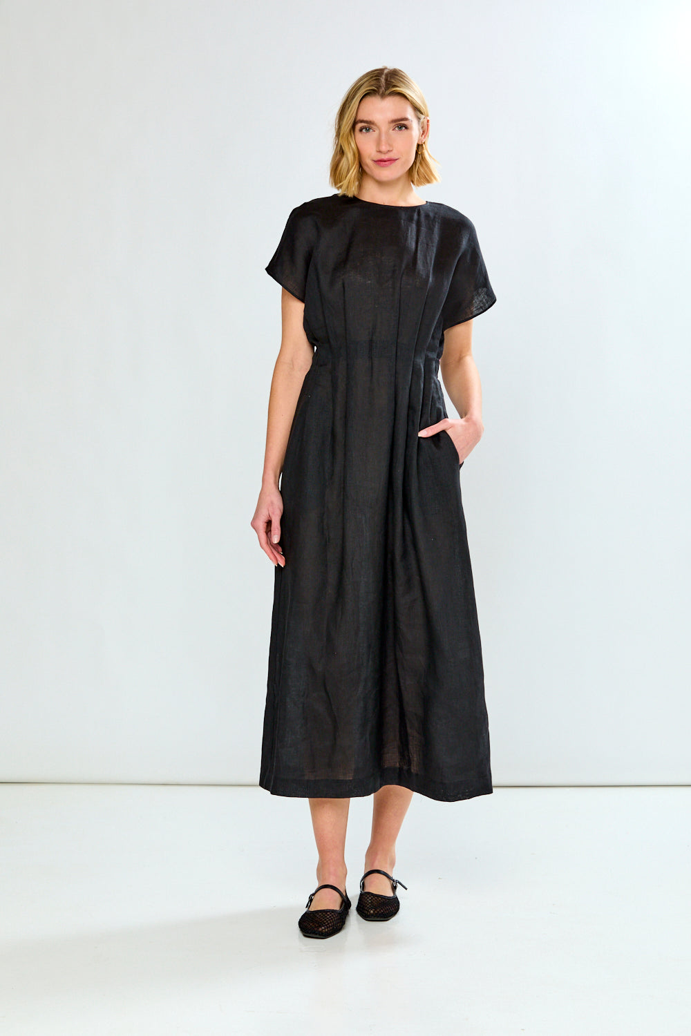 Woman wearing a black dress against a white background