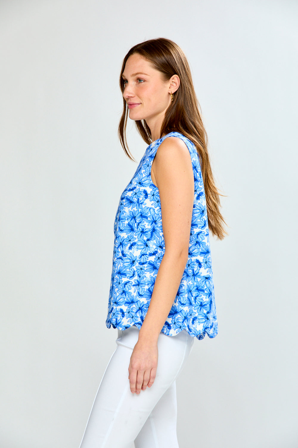 Woman wearing a blue floral sleeveless top against a white background