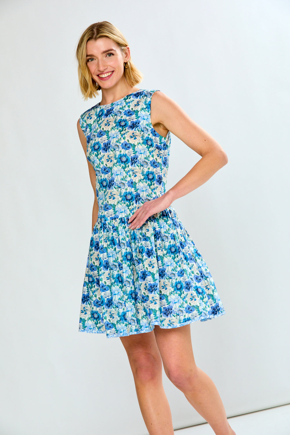 Woman wearing a blue floral dress against a white background